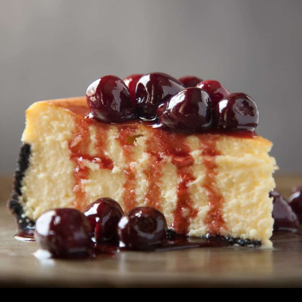Classic New York Cheesecake with a Chocolate Cookie Crust and Roasted Cherries is a heavenly cloud of silky perfection. Rich, creamy, and ethereally light.