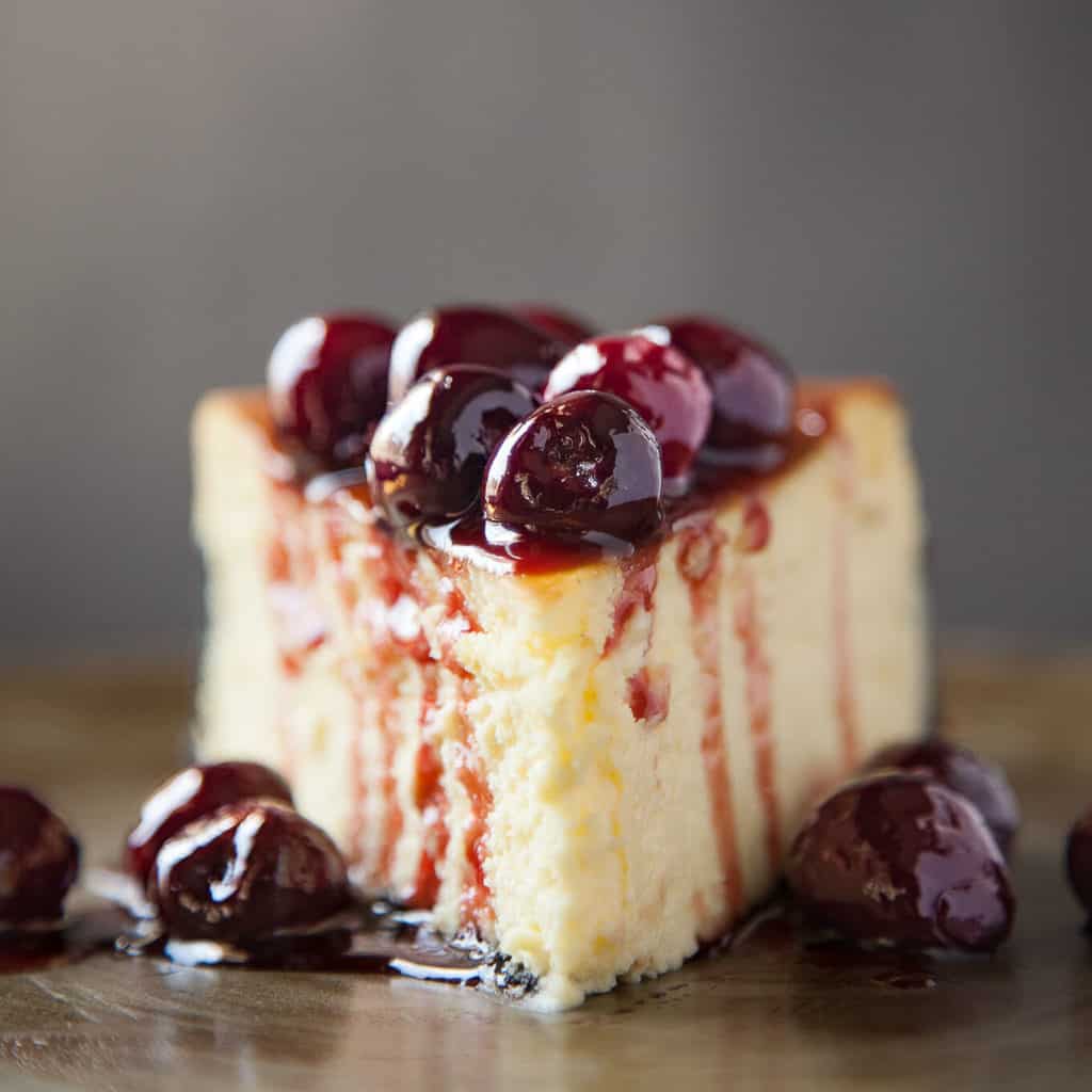 Classic New York Cheesecake with a Chocolate Cookie Crust and Roasted Cherries is a heavenly cloud of silky perfection. Rich, creamy, and ethereally light.