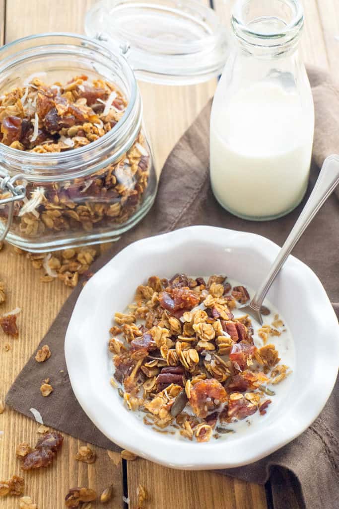 Maple Pecan Pumpkin Spice Granola - Crunchy clusters of maple sweetened granola with whole rolled oats, pecans, dates, pepitas, coconut, and warm pumpkin spice.