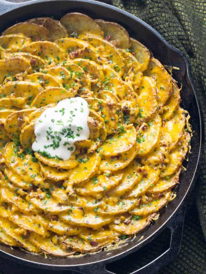 Bacon and Cheddar Spiral Loaded Roasted Potatoes are arranged in a vertical spiral for maximum crispness, roasted with bacon tucked into every little crevice, then topped with cheddar, chives, and sour cream. The BEST potato dish!