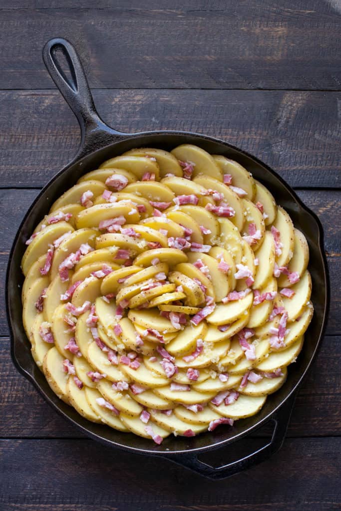 Spiral Roasted Potatoes - Potato slices tossed with lots of garlic, arranged in a vertical spiral for maximum crispness, roasted with bacon tucked into every little crevice. The BEST way to cook potatoes!
