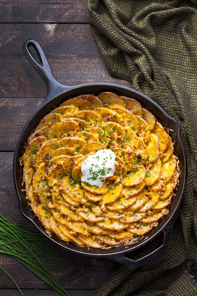 Bacon and Cheddar Spiral Loaded Roasted Potatoes are arranged in a vertical spiral for maximum crispness, roasted with bacon tucked into every little crevice, then topped with cheddar, chives, and sour cream. The BEST potato dish!