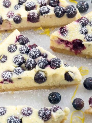 Lemon Blueberry Cheesecake Bars - rich, creamy cheesecake with flecks of lemon zest and studded with juicy blueberries on a shortbread crust. All the deliciousness of cheesecake in a quick and easy bar.
