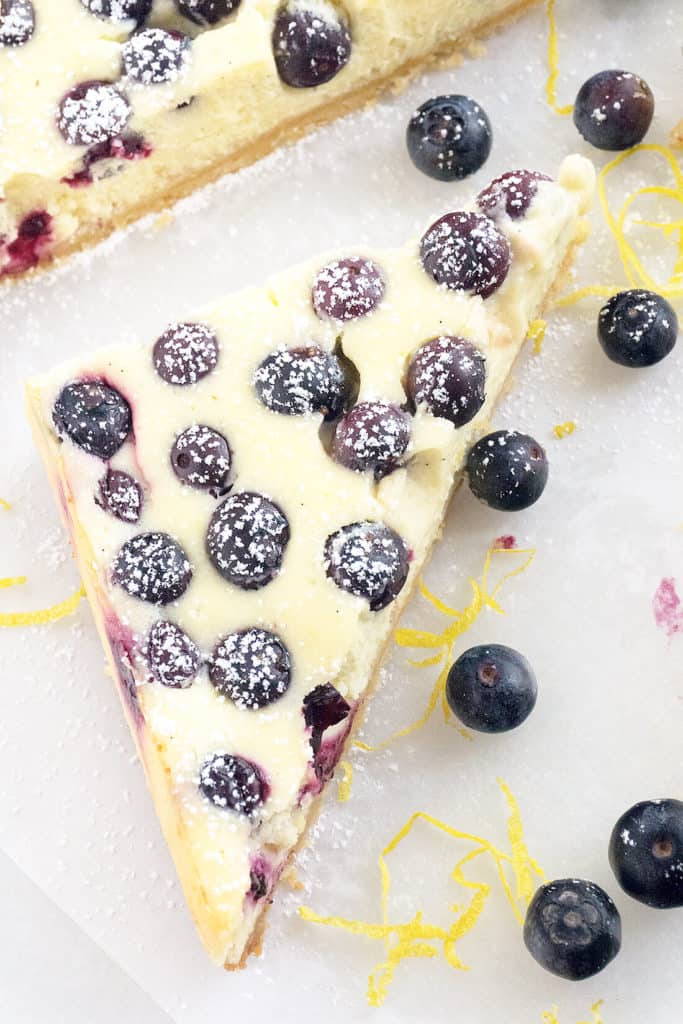 Lemon Blueberry Cheesecake Bars - rich, creamy cheesecake with flecks of lemon zest and studded with juicy blueberries on a shortbread crust. All the deliciousness of cheesecake in a quick and easy bar.