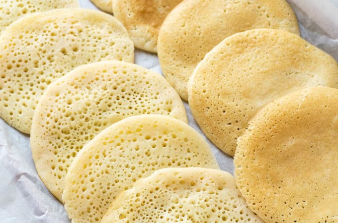 A Step by Step tutorial to making Qatayef, or Middle Eastern Semolina Pancakes, a traditional Arabic pastry very popular during the fasting month of Ramadan. They are stuffed with a variety of fillings, the most common being nuts or sweet cheese, then fried and dipped in Rose Water Syrup.
