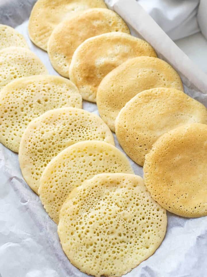 A Step by Step tutorial to making Qatayef, or Middle Eastern Semolina Pancakes, a traditional Arabic pastry very popular during the fasting month of Ramadan. They are stuffed with a variety of fillings, the most common being nuts or sweet cheese, then fried and dipped in Rose Water Syrup.