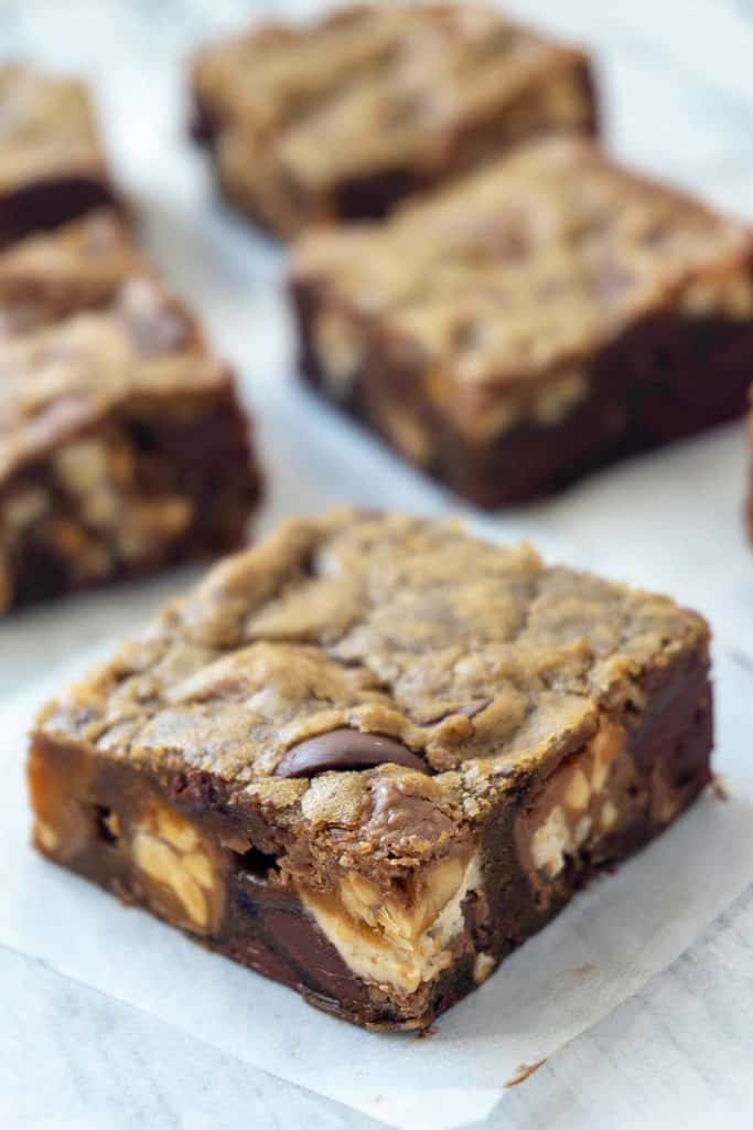 Thick and chewy Snickers Blondie Bars - a rich, dense blondie packed with chunks of Snickers bars and chocolate chips - irresistible! 