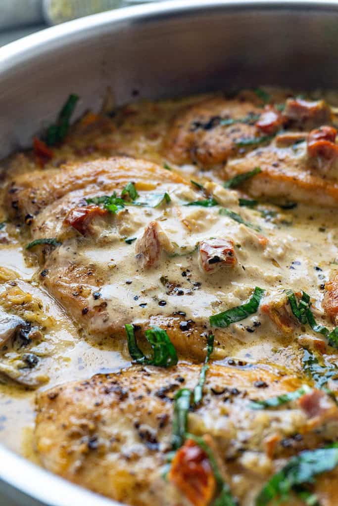 Tender, juicy chicken breasts in a creamy parmesan sauce with sun dried tomatoes and mushrooms - this Chicken with Sun Dried Tomato Cream Sauce is full of flavor and ready in under 30 minutes. Elegant enough for a date night, quick and easy enough for a weeknight dinner. Sure to be a family favorite!