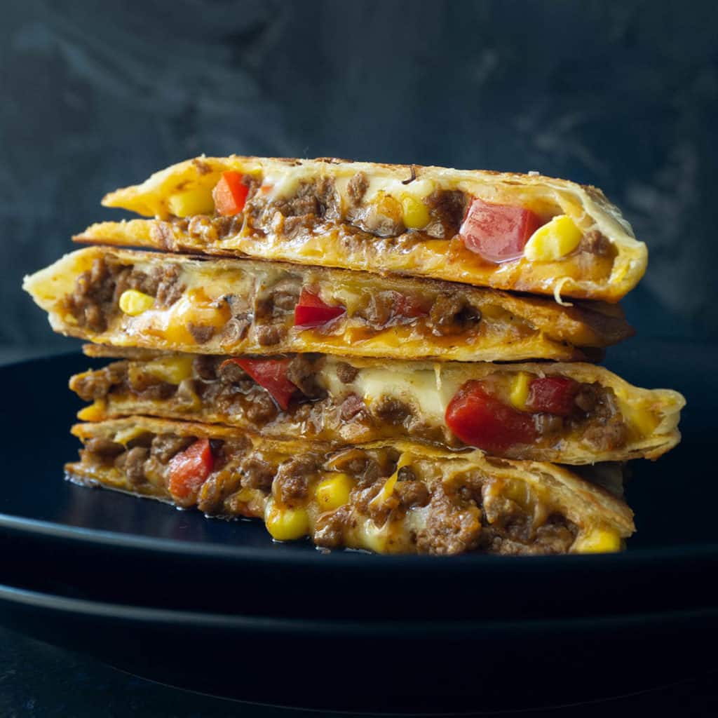A crispy tortilla filled with refried beans, melted cheddar and Monterey jack cheeses, sweet corn, red bell pepper, and juicy, Mexican-spiced ground beef - these Beefy Bean and Cheese Quesadillas are a family favorite. If only restaurant quality was this awesome! Added bonus - they are super quick and easy to make.