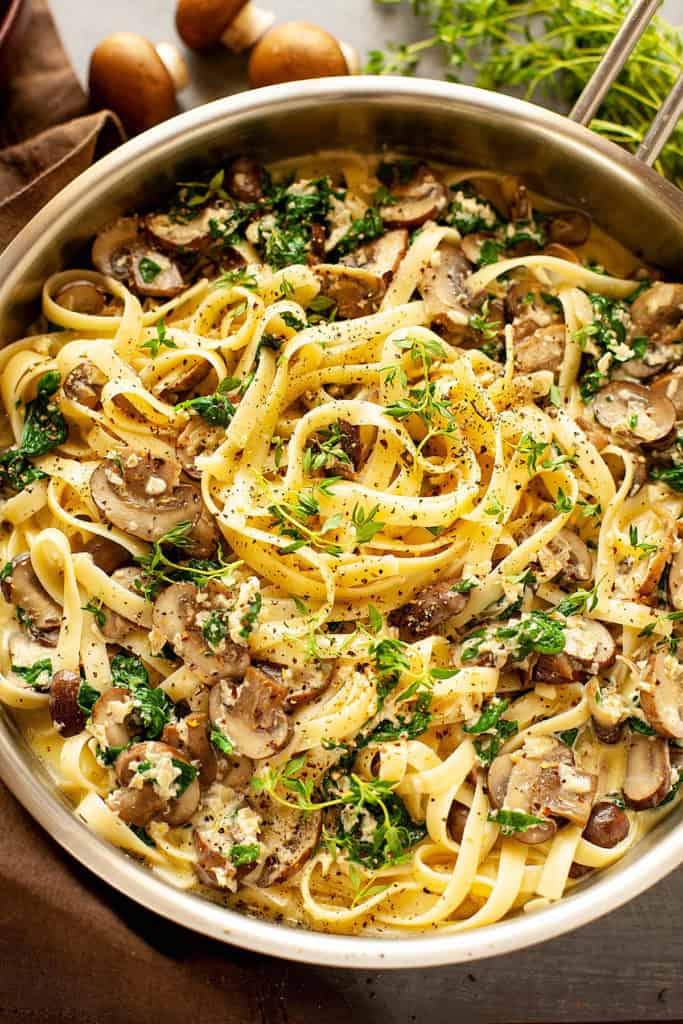Creamy, Cheesy Mushroom Spinach Pasta - sautéed mushrooms and baby spinach tossed with buttered fettucine in a garlicky, parmesan cream sauce. So delicious and so quick and easy to make! This dish is all flavor. You've got to love a restaurant quality meal that's ready in under 30 minutes.