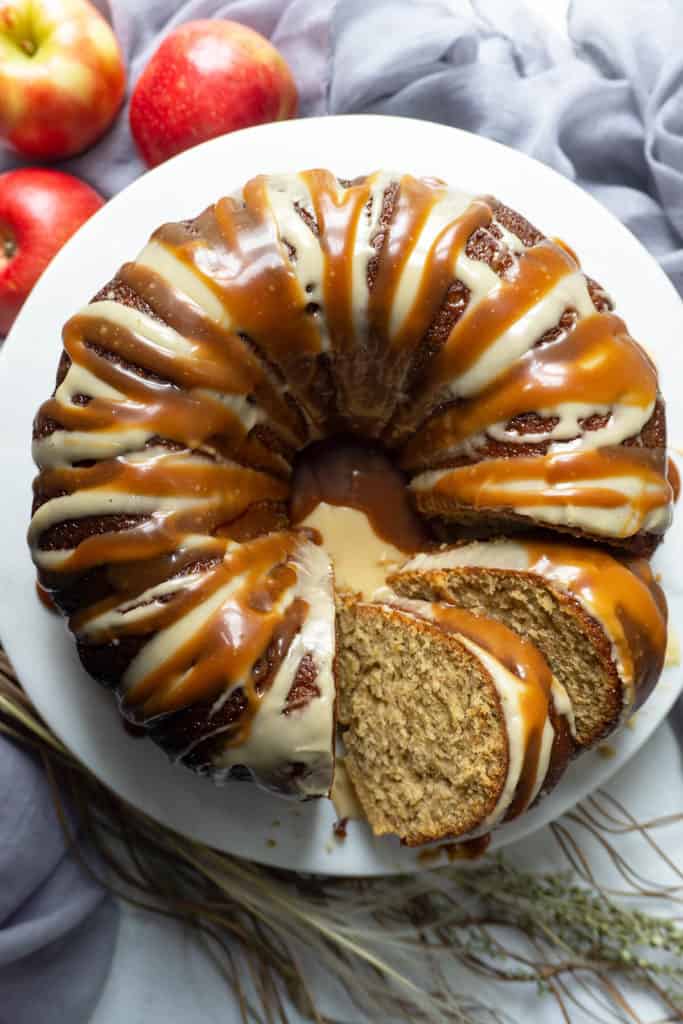 This Triple Glazed Caramel Apple Cider Cake is bursting with apple and the flavors of autumn! Shredded apples and an intense apple cider syrup flavor the moist, tender cake. Three glazes send it right over the top - an apple cider syrup glaze, an apple cider icing, and a caramel drizzle. #applecake #applecidercake #apple #applecider #falldesserts #desserts #dessertrecipes #recipe #easy #caramel #cake #bundt #easydessert #dessertfoodrecipes #easyrecipes #cakerecipes #bundtbakers #bundtcake