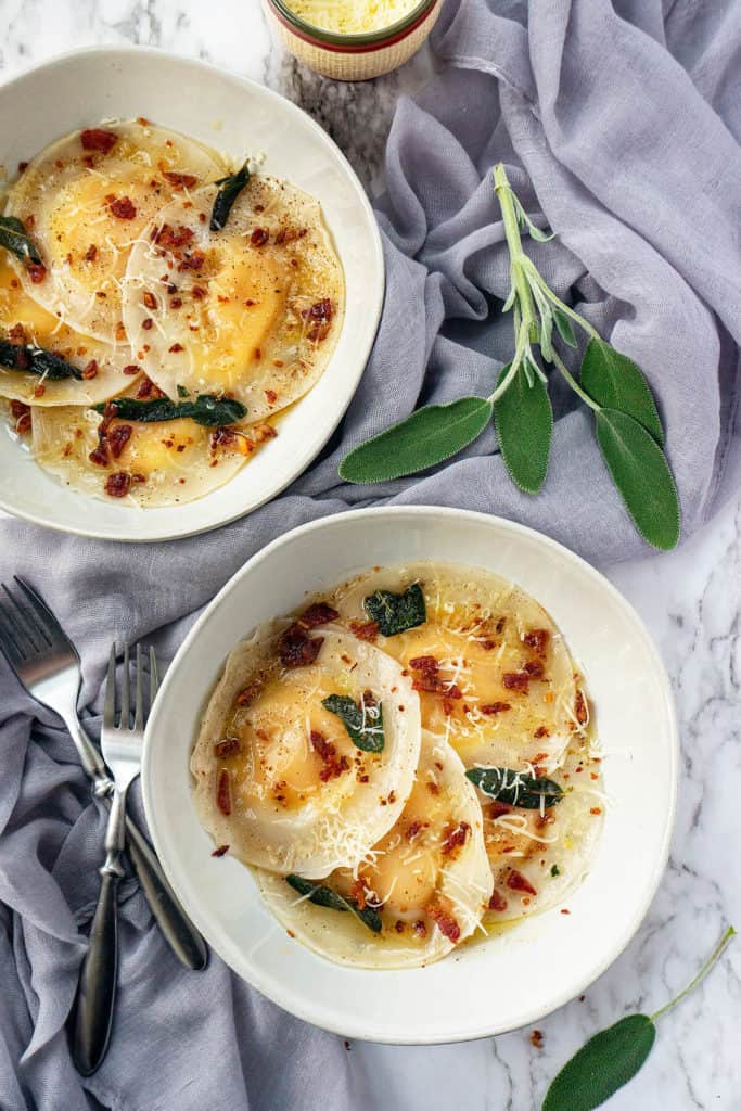 Butternut Squash Ravioli topped with crispy sage, browned butter, and crunchy bacon – my favorite dish for fall! Easy to make with dumpling or wonton wrappers. Truly comfort food at its finest! #ravioli #butternut #butternutsquash #butternutsquashrecipes #pasta #pastafoodrecipes #recipesfordinner #recipeseasyfast #easy #shortcut #shortcutfoodie #easydinner #easydinnerrecipes #easydinnerideas