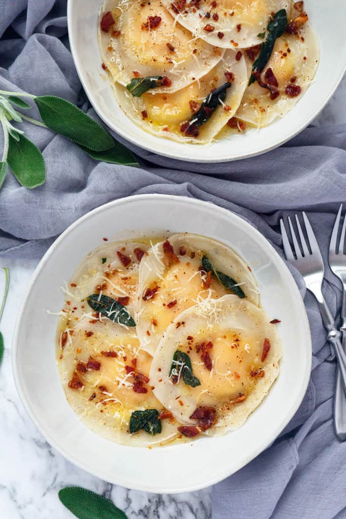 Butternut Squash Ravioli topped with crispy sage, browned butter, and crunchy bacon – my favorite dish for fall! Easy to make with dumpling or wonton wrappers. Truly comfort food at its finest! #ravioli #butternut #butternutsquash #butternutsquashrecipes #pasta #pastafoodrecipes #recipesfordinner #recipeseasyfast #easy #shortcut #shortcutfoodie #easydinner #easydinnerrecipes #easydinnerideas