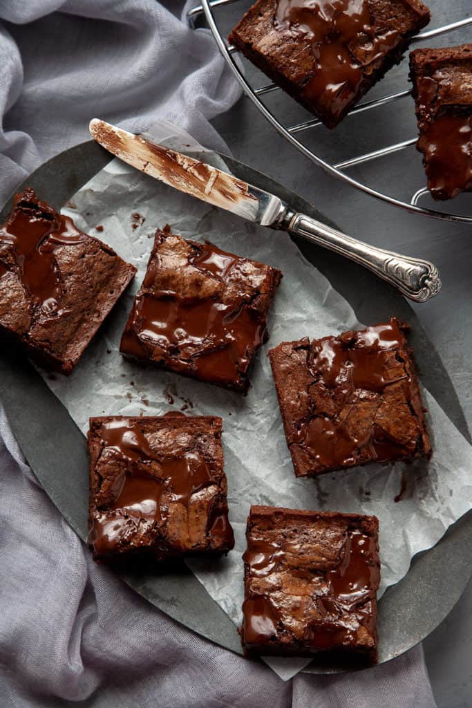 These Ultimate Fudgy, Chewy Brownies are dense, moist, and intensely chocolatey with a crackly top and puddles of molten chocolate. Somewhere between a rich truffle torte and a piece of fudge, their chewy texture is absolute perfection. #brownies #dessert #fudgy #chewy #chocolate #best #easy