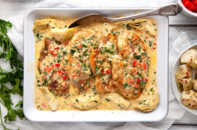 These Creamy Artichoke Chicken Breasts are irresistible! Sautéed chicken breasts are in a lemony, garlicky parmesan cream sauce with artichokes, red peppers, and parsley. On the table in 15 minutes. Quick, easy, delicious. #chicken #chickenbreasts #chickendinner #quick #easy #under30minutes #recipe #lowcarb #keto