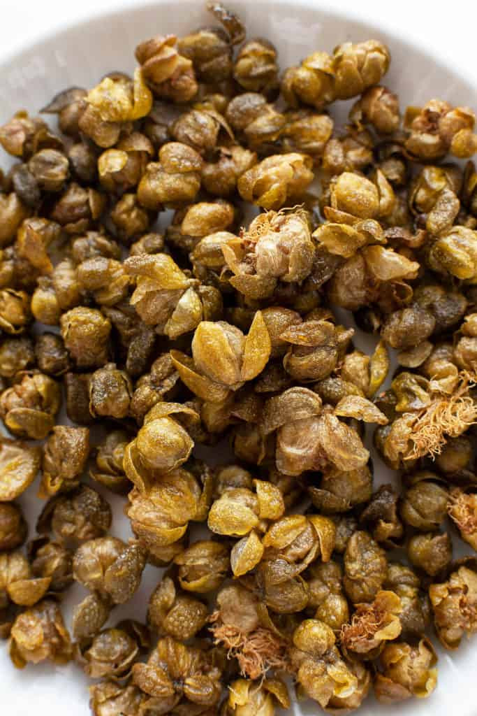 Crispy, nutty, and briny, Fried Capers are magical little flavor bombs that add an incredible dimension of flavor and texture to salads, pasta, meat, and vegetable dishes. #garnish #italian #recipe #easy #quick #flavor #fried #whatare #howtouse