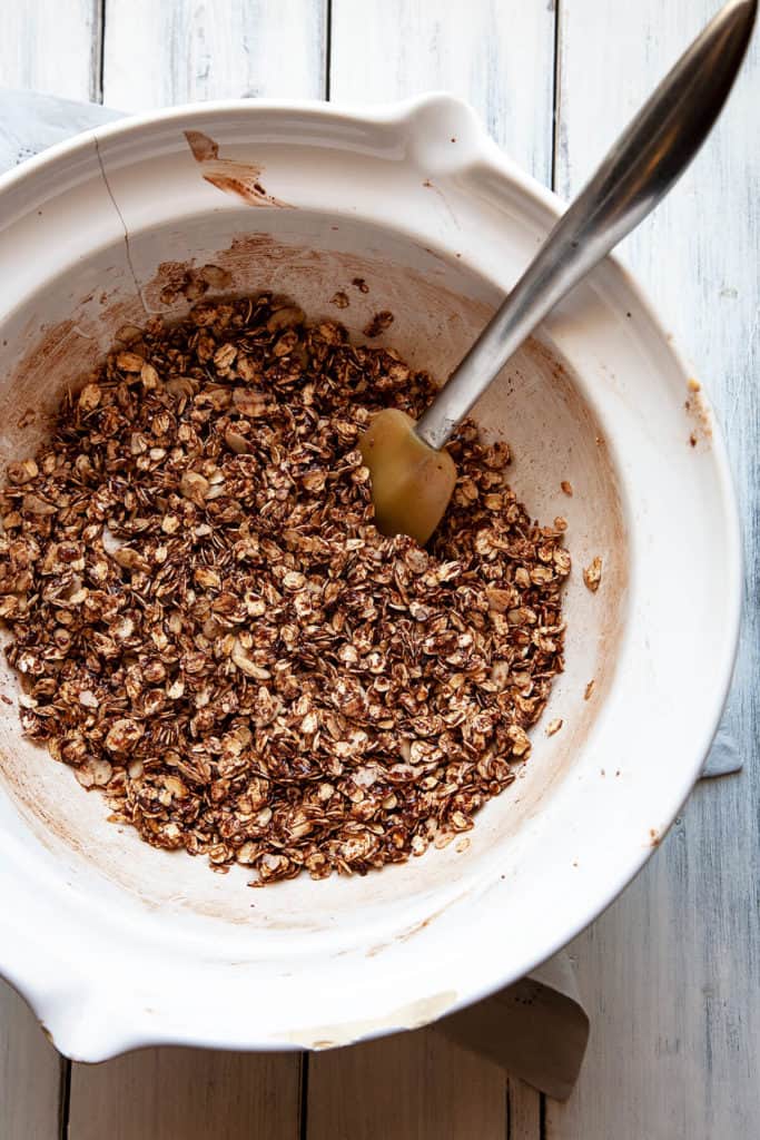 Double Chocolate Granola - crunchy chocolate oat clusters, sliced almonds, flakes of coconut, and best of all – a decadent chocolate coating. Sprinkled with raw sugar for even more crunch. Chocolate for breakfast? Yes, please! #granola #recipe #chocolate #cocoa #breakfast #easy #quick