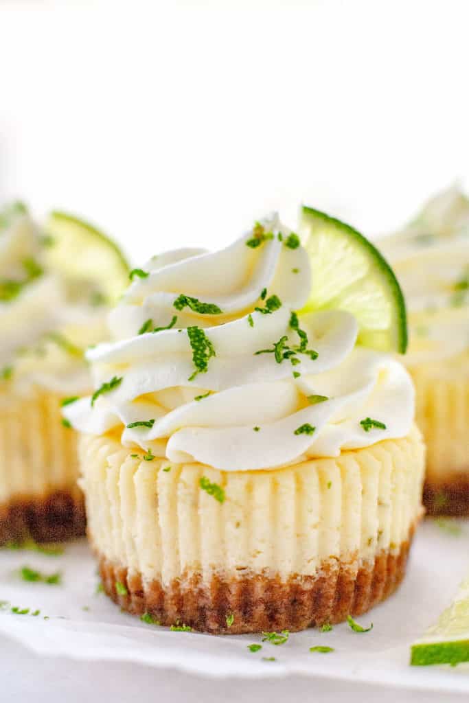 These Mini Key Lime Cheesecakes are the perfect combination of creamy, tart, and sweet in the cutest little cakes. Quick and easy to make using a muffin pan and paper liners. #cheesecake #mini #keylime #lime #dessert #recipe #easy #baked