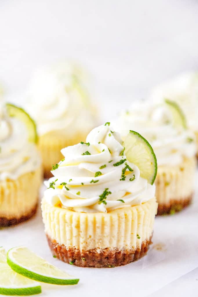 These Mini Key Lime Cheesecakes are the perfect combination of creamy, tart, and sweet in the cutest little cakes. Quick and easy to make using a muffin pan and paper liners. #cheesecake #mini #keylime #lime #dessert #recipe #easy #baked 