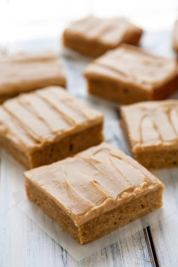 These Banana Blondies are dense yet soft, moist, and full of sweet banana flavor. Topped with a creamy, caramely brown sugar frosting, they’re irresistible! #recipe #easy #dessert #sweet #banana #frosting #blondies #brownsugar #bakesale #potluck #best