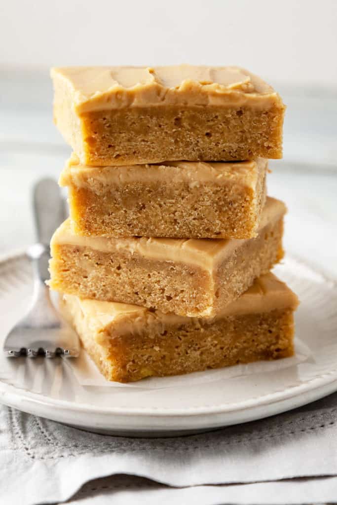 These Banana Blondies are dense yet soft, moist, and full of sweet banana flavor. Topped with a creamy, caramely brown sugar frosting, they’re irresistible! #recipe #easy #dessert #sweet #banana #frosting #blondies #brownsugar #bakesale #potluck #best
