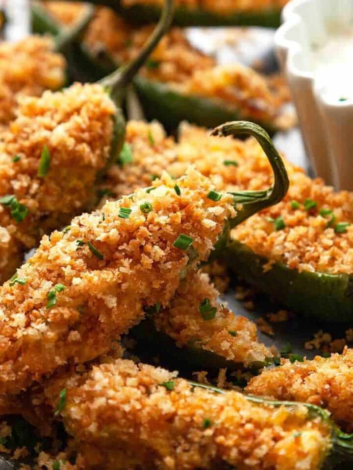Jalapeno Poppers are a game day favorite! Fresh jalapenos filled with a creamy cheese and bacon filling, topped with crispy panko, and baked to golden-brown crispy perfection. #jalapeno popper #recipe #easy #baked #bacon #video #cheddar #cream cheese #vegetarian #best #stuffed #oven #healthy #appetizers #party #game day