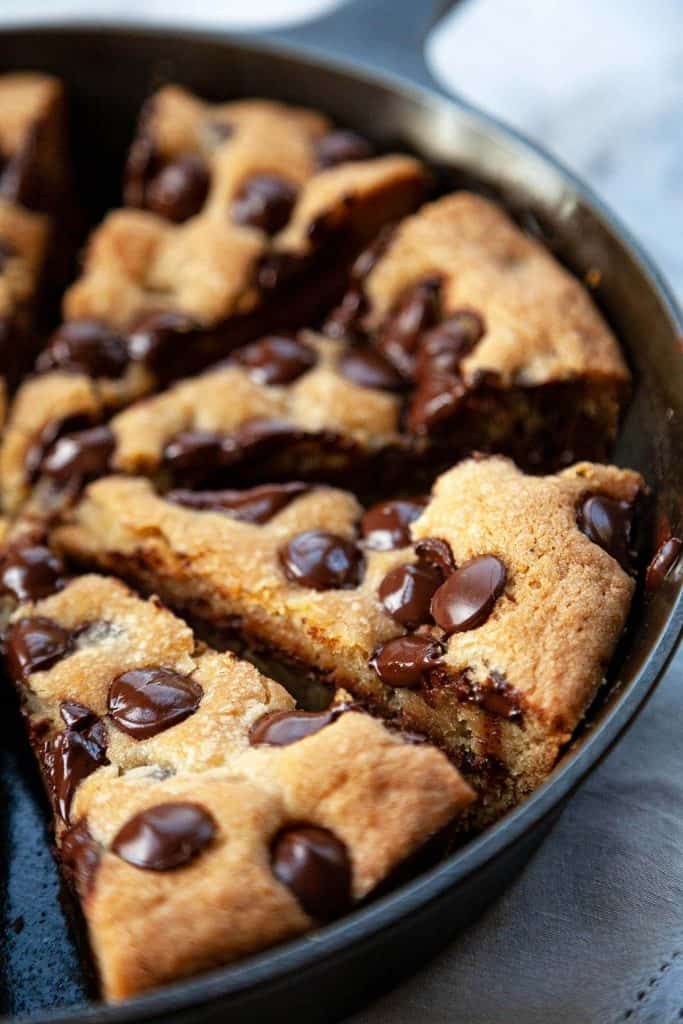 Nutella-Stuffed, Deep Dish, Chocolate Chip Skillet Cookie - A crispy, chewy, buttery chocolate chip cookie on the outside and an irresistible, ooey-gooey Nutella-stuffed center, baked in a cast iron pan. Serve warm from the oven with vanilla ice cream for the ultimate dessert! #skilletcookie #castiron #easy #chocolatechip #withpremadedough #videos #recipe #gooey #stuffed #nutella #giant #best #sundae #homemade #deepdish #12inch #10inch #individual