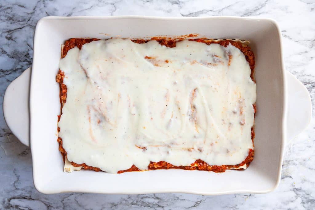 Classic Lasagna - layers of silky smooth, creamy parmesan béchamel sauce, a slow simmered Bolognese meat sauce, sheets of pasta, and lots of mozzarella cheese make this the World’s Best Lasagna recipe.