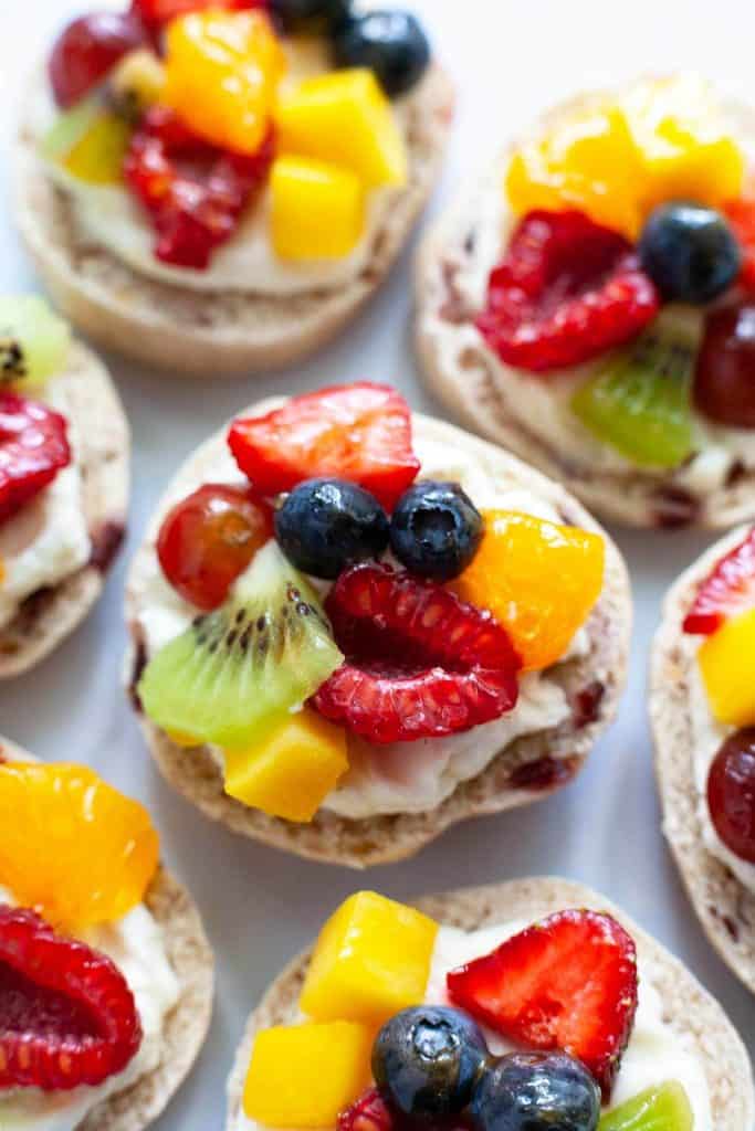 Mini Fruit Pizzas with fresh juicy fruit, velvety smooth cream cheese, and a soft, chewy crust. A delicious and healthy snack your whole family will love! Quick and easy to make with wholesome ingredients you can feel good about serving. 