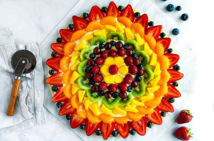 Fruit Pizza - The BEST summer dessert! With a soft sugar cookie crust, dreamy cream cheese frosting, and topped with fresh fruit. Super simple to make and always a hit!