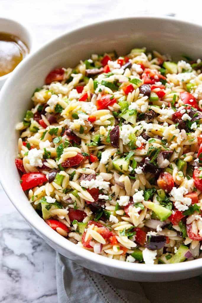 Quick and easy to make Greek Orzo Salad is loaded with fresh crunchy veggies and all of your favorite Mediterranean flavors. This healthy pasta salad recipe is perfect for picnics, potlucks, or barbeques or as an easy, flavorful side dish for dinner.