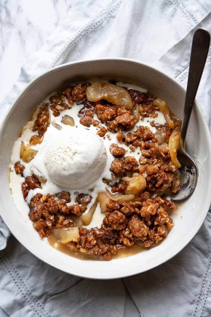 Quick and Easy Apple Crisp is bursting with sweet, juicy apples and a crunchy oat topping. This easy fruit crisp recipe is perfect served warm from the oven topped with a scoop of vanilla ice cream. The quintessential fall dessert recipe!