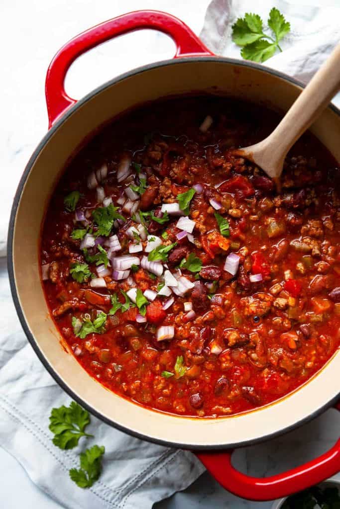 The best classic Chili recipe, ready in 30 minutes! Loaded with ground beef, tender beans, tomatoes, and a simple homemade blend of chili seasoning, piled high with all of your favorite toppings. So much flavor!