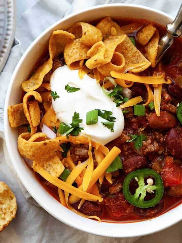 The best classic Chili recipe, ready in 30 minutes! Loaded with ground beef, tender beans, tomatoes, and a simple homemade blend of chili seasoning, piled high with all of your favorite toppings. So much flavor!
