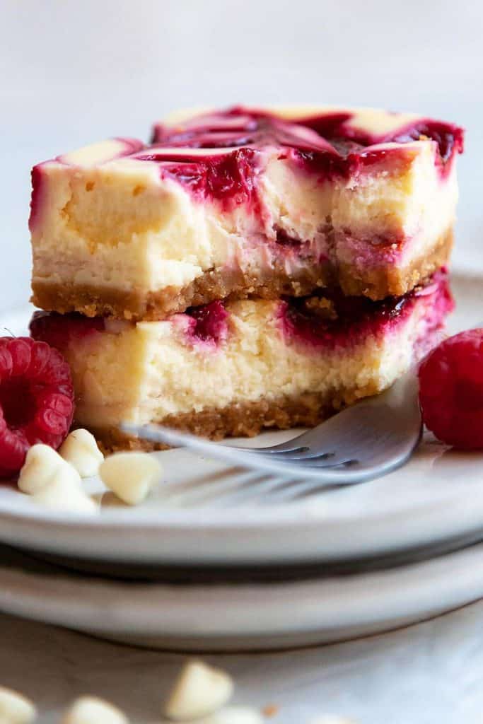 White Chocolate Raspberry Cheesecake Bars are lush and decadent with a rich and creamy, white chocolate cheesecake filling and a raspberry swirl. Super easy to make recipe and perfect for any occasion!
