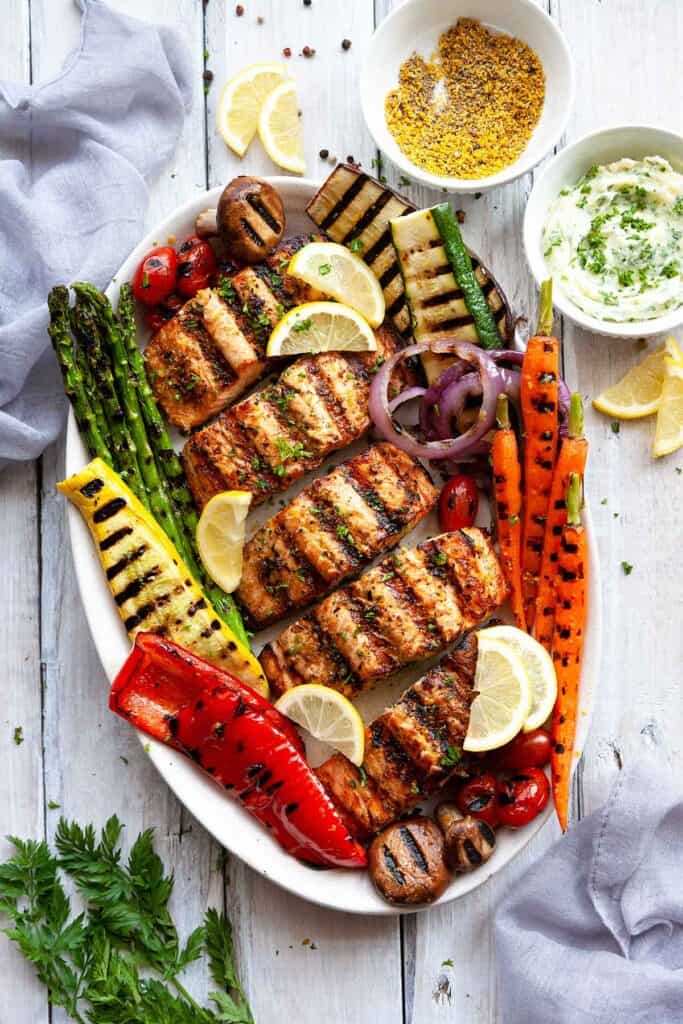 grilled salmon on a platter with grilled vegetables