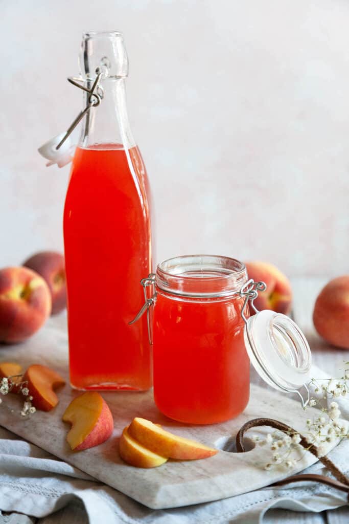 a bottle and a jar of peach syrup