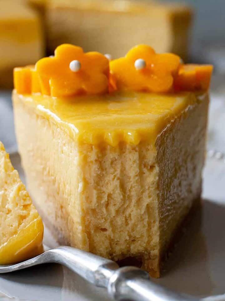 a slice of mango cheesecake with a bite taken out