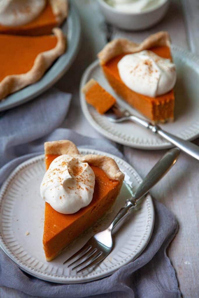 slices of sweet potato pies on plates with wihipped cream