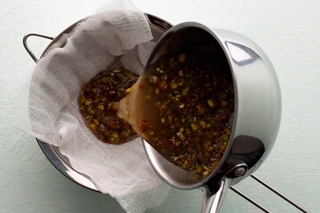 pouring pistachio syrup through strainer