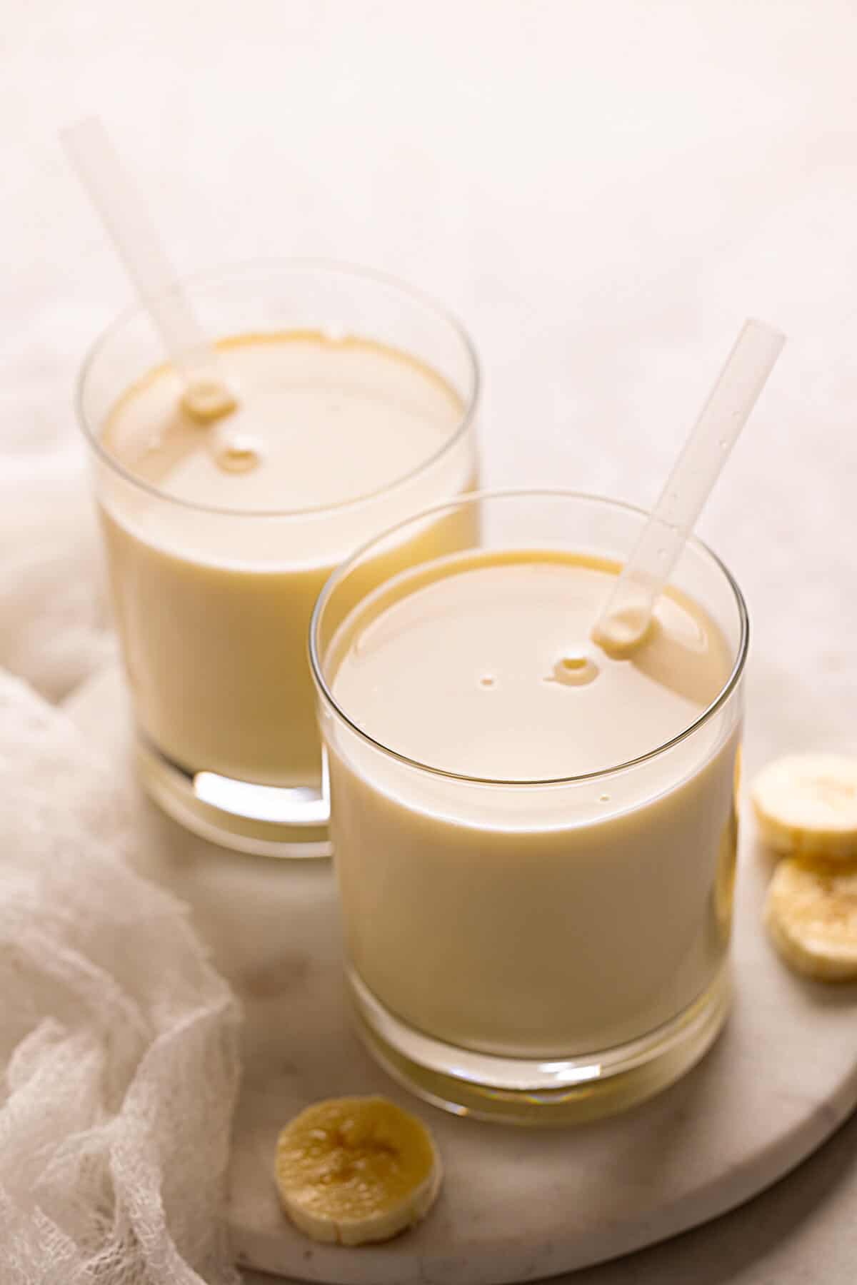two glasses of banana milk with straws
